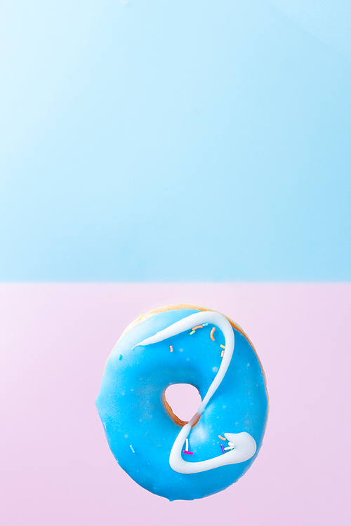 one fresh sweet doughnut on blue and pink background