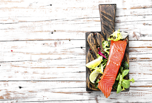 salmon with s and lettuce on cutting board.healthy food