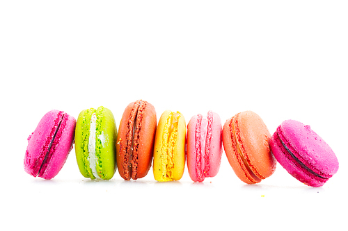 Multicolored macaroons cookies row isolated on white