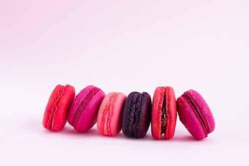 Pink macaroons cookies row on on pink background