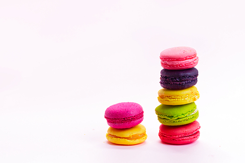 Pink macaroons cookies stacks on pink background with copy space