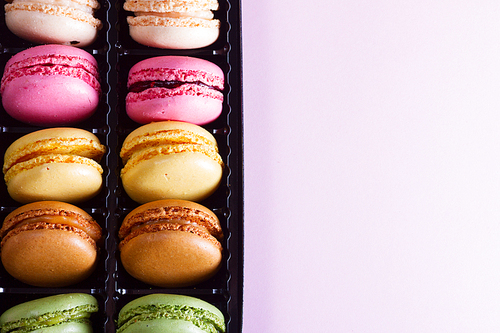 Close up background pile on fresh macaroons cookies, copy space on pink background