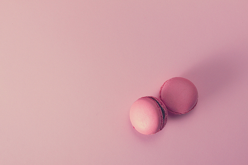 Two Macaroons cookies on pink background with copy space, retro toned