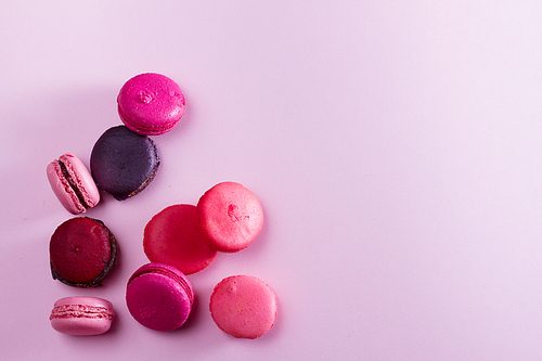 Pile of Macaroons cookies on pink background with copy space