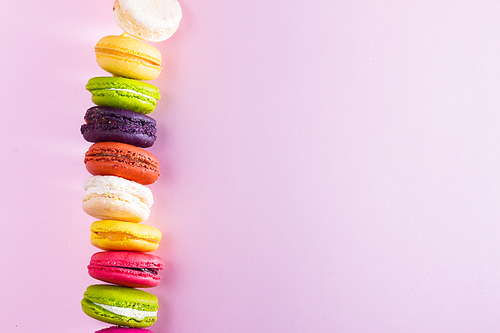 Macaroons cookies on pink background with copy space