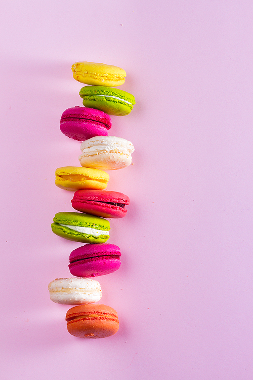 Macaroons cookies stack on pink background with copy space