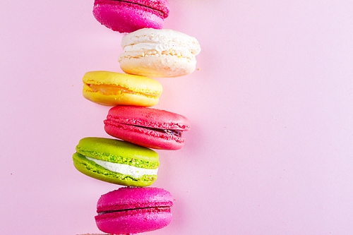 Macaroons cookies stack on pink background with copy space