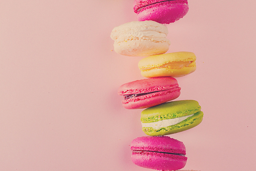 Macaroons cookies stack on pink background with copy space, retro toned