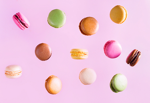 Assorted macaroons falling cookies on pink background