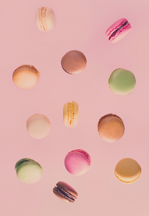 Assorted macaroons falling cookies on pink background, retro toned