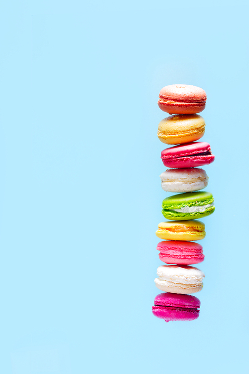 Assorted macaroons cookies tower with copy space on blue background