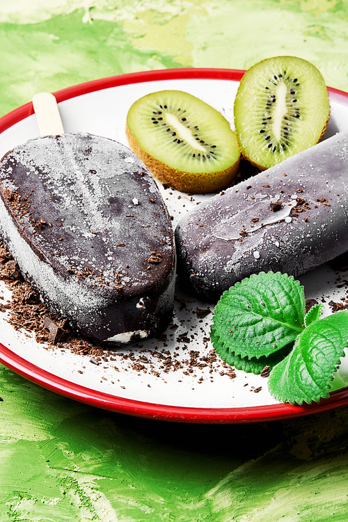Two ice cream coated in chocolate with kiwi