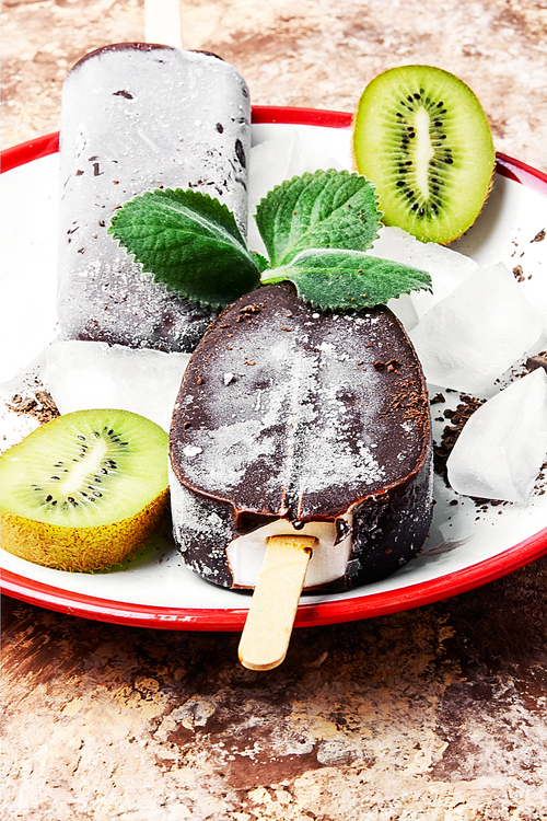 Two ice cream coated in chocolate with kiwi