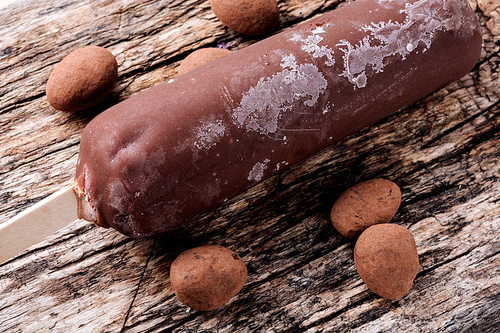 Chocolate ice cream on wooden background.Popsicle and sweet dessert