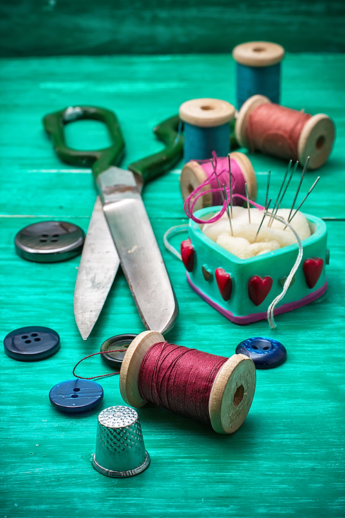 thread buttons for crafts on turquoise wooden background.Selective focus