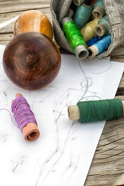 bag sewing thread and a sketch on a wooden table