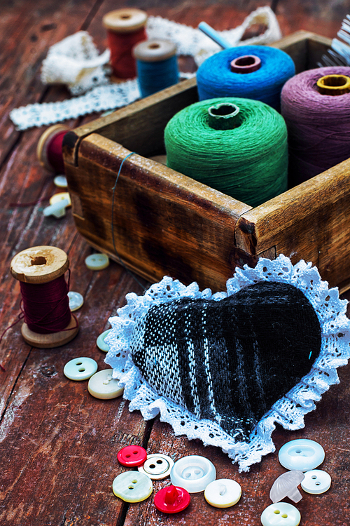 button and spools of thread for needlework on bright background