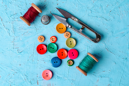 Set of  pied buttons for garment with threads on blue background