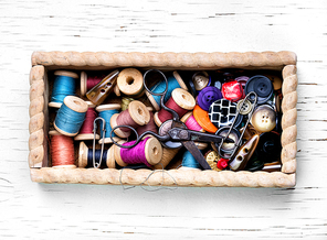 Wooden retro box, with thread spools and buttons. Sewing accessories.