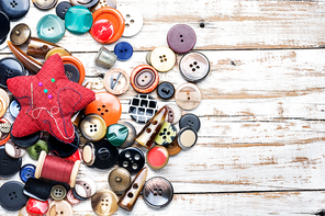 Spools of threads and buttons on wooden table