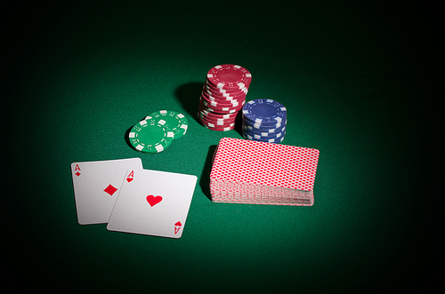 Chips and playing cards on green table