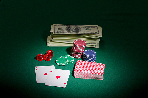 Dollars chips cards and dices on green table