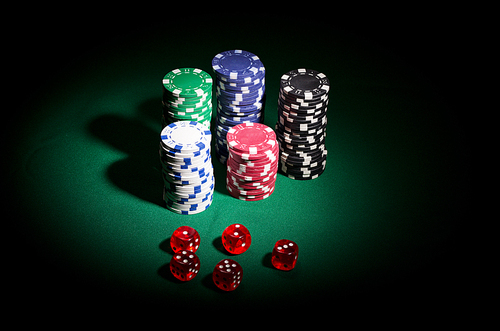 Gambling chips and dices on green table