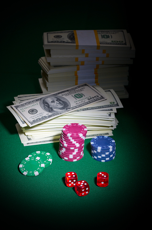 Dices chips and dollars on green table