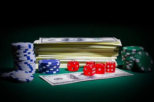Dollars chips and dices on green table