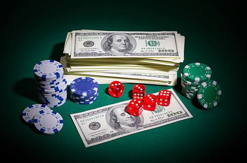 Dollars chips and dices on green table