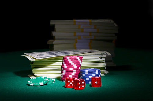 Dollars chips and dices on green table