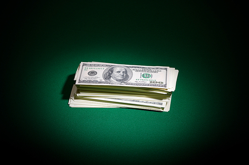 Stack of dollars on green table