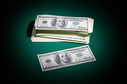 Stack of dollars on green table