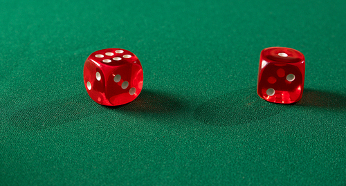 Red gambling dices on green table