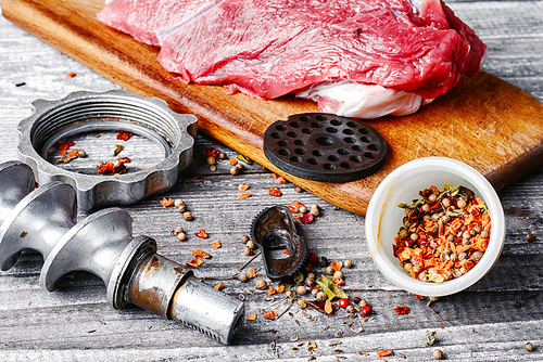 Raw beef on chopping board and kitchen utensils