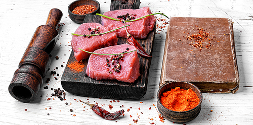 Three raw chops veal steak with peppers and spices