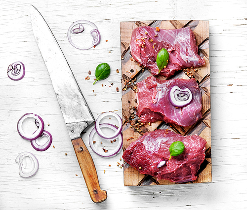 Raw beef meat on cutting board with spices