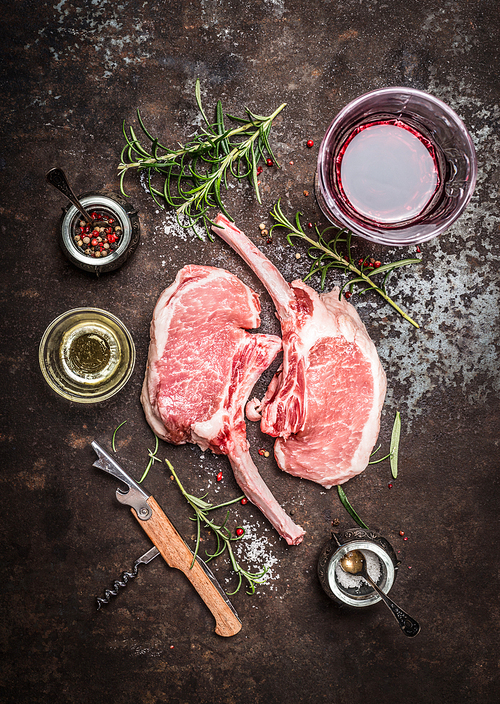 Raw Porco Iberico meat ribs cutlet with ingredients and glass of red wine on rustic metal background, top view.  Frenched Racks meat