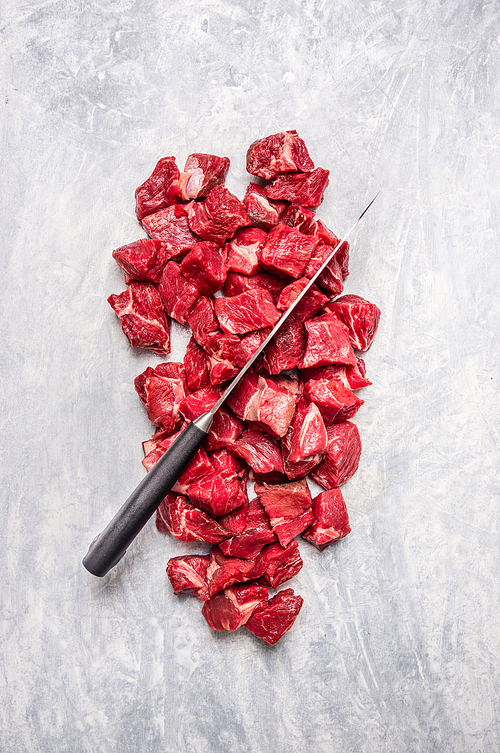 chopped meat with knife on light wooden background, top view