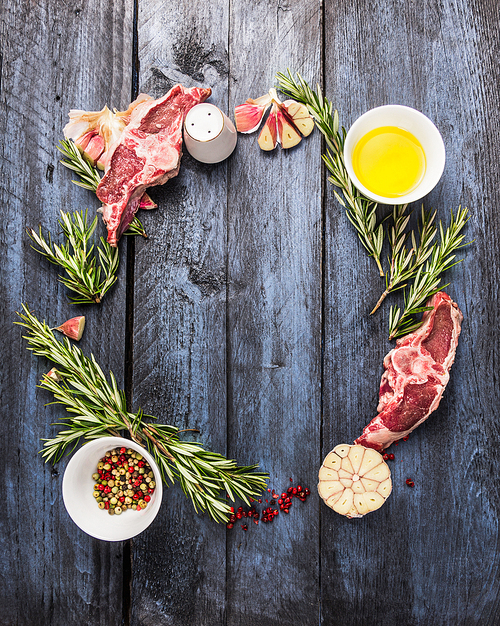 raw lamb meat circle frame with rosemary herbs, garlic and oil, on  blue wooden background, top view