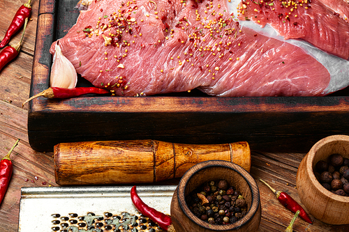 Raw beef meat on a cutting board.Beef with spice and on a wooden table