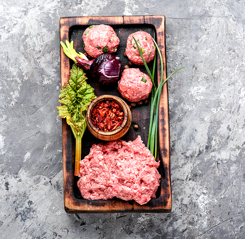 Fresh raw minced beef on cutting board and ingredients.Mince.