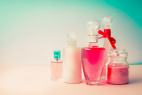 Cosmetic products collection with various bottles : tonic,lotion, perfume, Moisturizer, cream, soups, foams, shampoo on Beautiful  pink turquoise blue background, front view. Cosmetic  shop concept