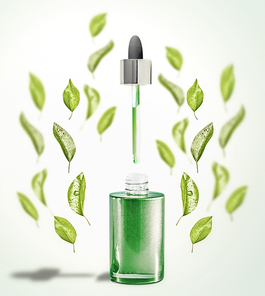 Green facial Serum or oil bottle with pipette and green leaves. Modern skin care and beauty natural cosmetic concept
