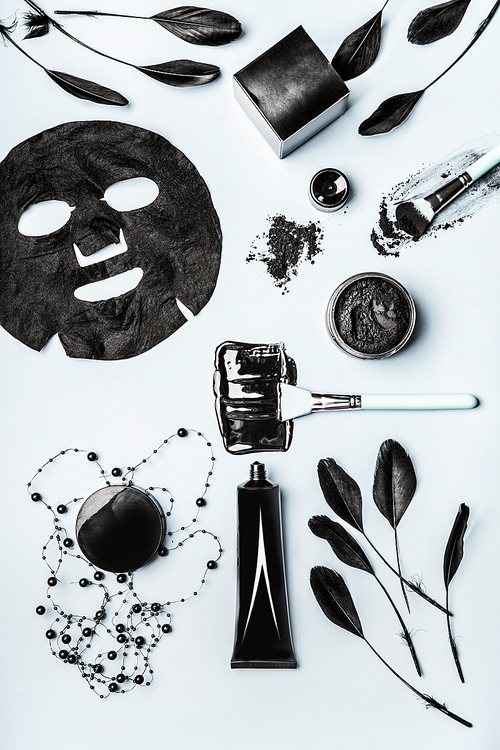 Beauty facial cosmetic products with Activated Charcoal: powder, Black head Mask, sheet mask and beauty tools accessories , top view, flat lay. Modern skin care concept