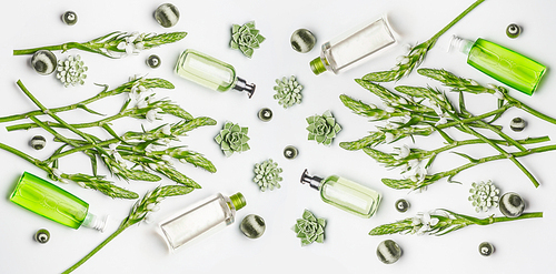 Green herbal vegan natural cosmetic setting with bottles of skin care products with branding copy space, herbs and flowers on white background , top view, flat lay. Beauty  concept