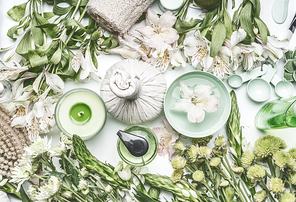 Green herbal spa setting with water bowl, flowers, candle, massage  balls, cosmetic products, herbs and flowers, top view. Beauty,  healthy lifestyle and wellness concept