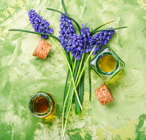 Lavender oil in glass bottle on a background of fresh flowers.
