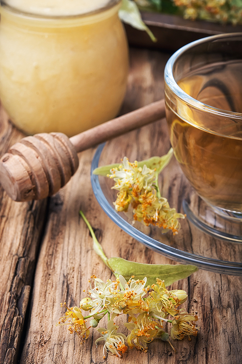 Glass cup of herbal tea and lime healing honey