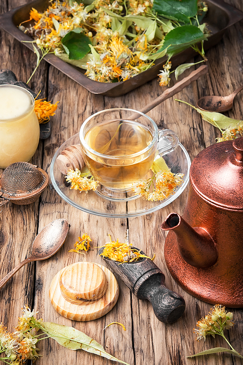 Glass cup of herbal tea and lime healing honey